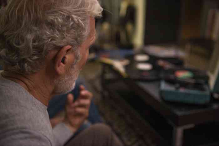 A man wearing hearind aid while listening to music