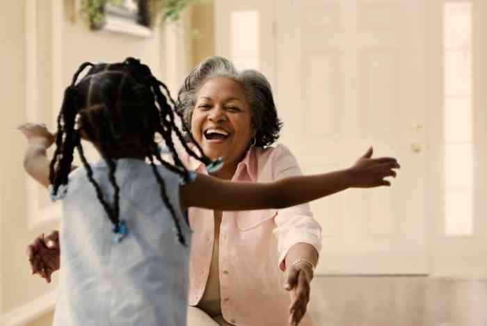 a smiling grandmother ready to hug her granddaughter